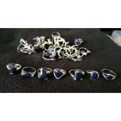 Lot verzilverde dames ringen met blauwe goudsteen 37 stuks.