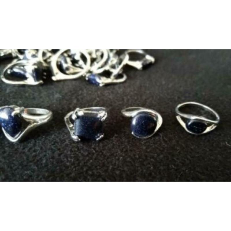 Lot verzilverde dames ringen met blauwe goudsteen 37 stuks.